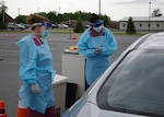 Nikki Loehr (left) and Mary Paul (right), both nurses with the Bowe Army Medical Home COVID-positive treatment team and natives of Chicago, speak to a 10th Mountain Division (LI) Soldier before administering a COVID-19 nasal swab test on Fort Drum, N.Y. June 9.