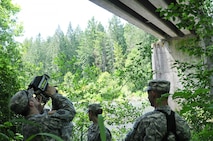 Spc. Christopher Carr (left) and Spc. William Belanger (right) with the 610th Engineer Support Company use a laser range finder to gather and record data on the Nisqually River Bridge while training with the new ENFIRE system June 5. Soldiers with the 14th Eng. Bn., spent a week training on the ENFIRE system which is a digital reconnaissance and surveying equipment instrument set. (US Army photo by Sgt. Austan R. Owen.)