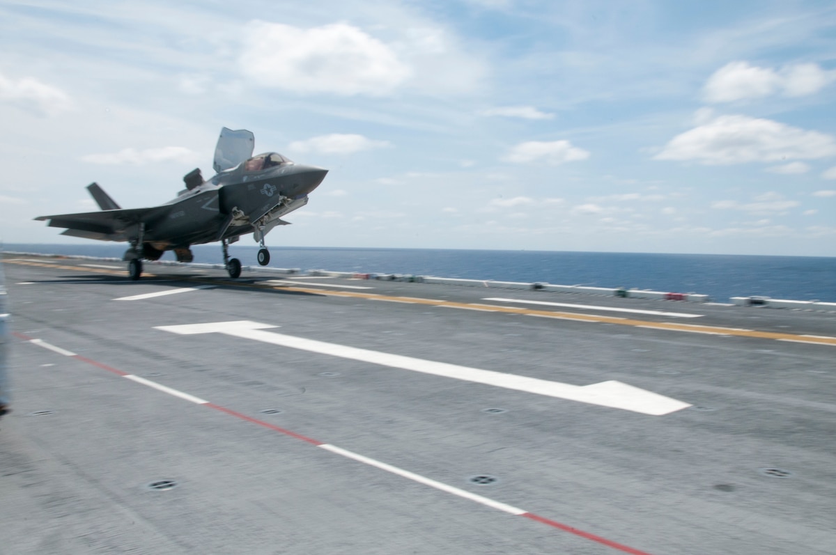 As fast as its name, an F-35B Lightning II screams past a flight deck handler as it takes off during flight operations aboard the amphibious assault ship USS Wasp (LHD 1)