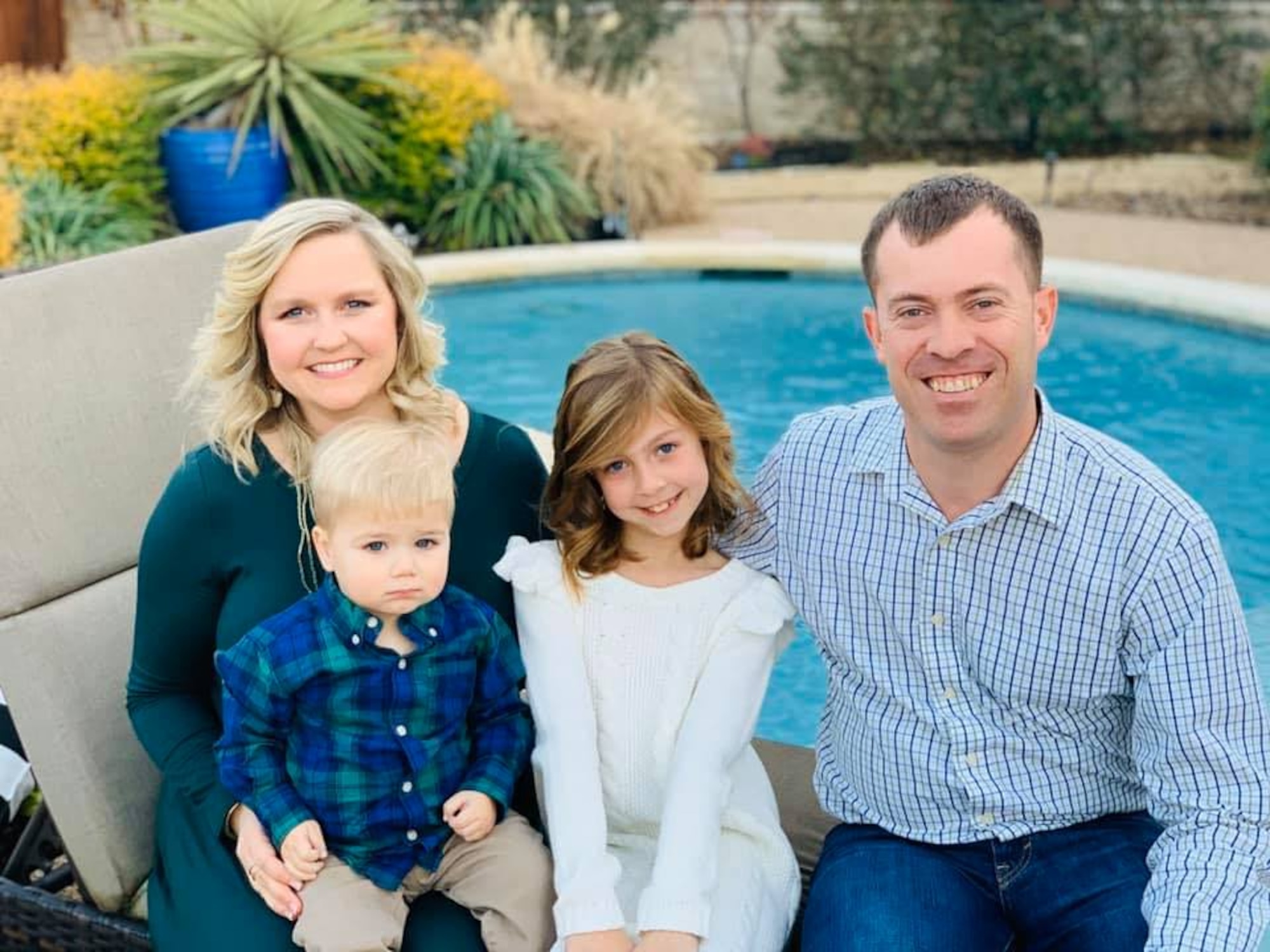 Family sits by pool