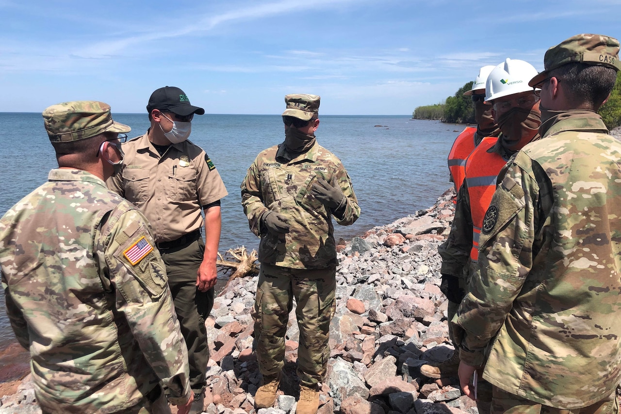 Soldiers and state employees discuss a project at a state park.