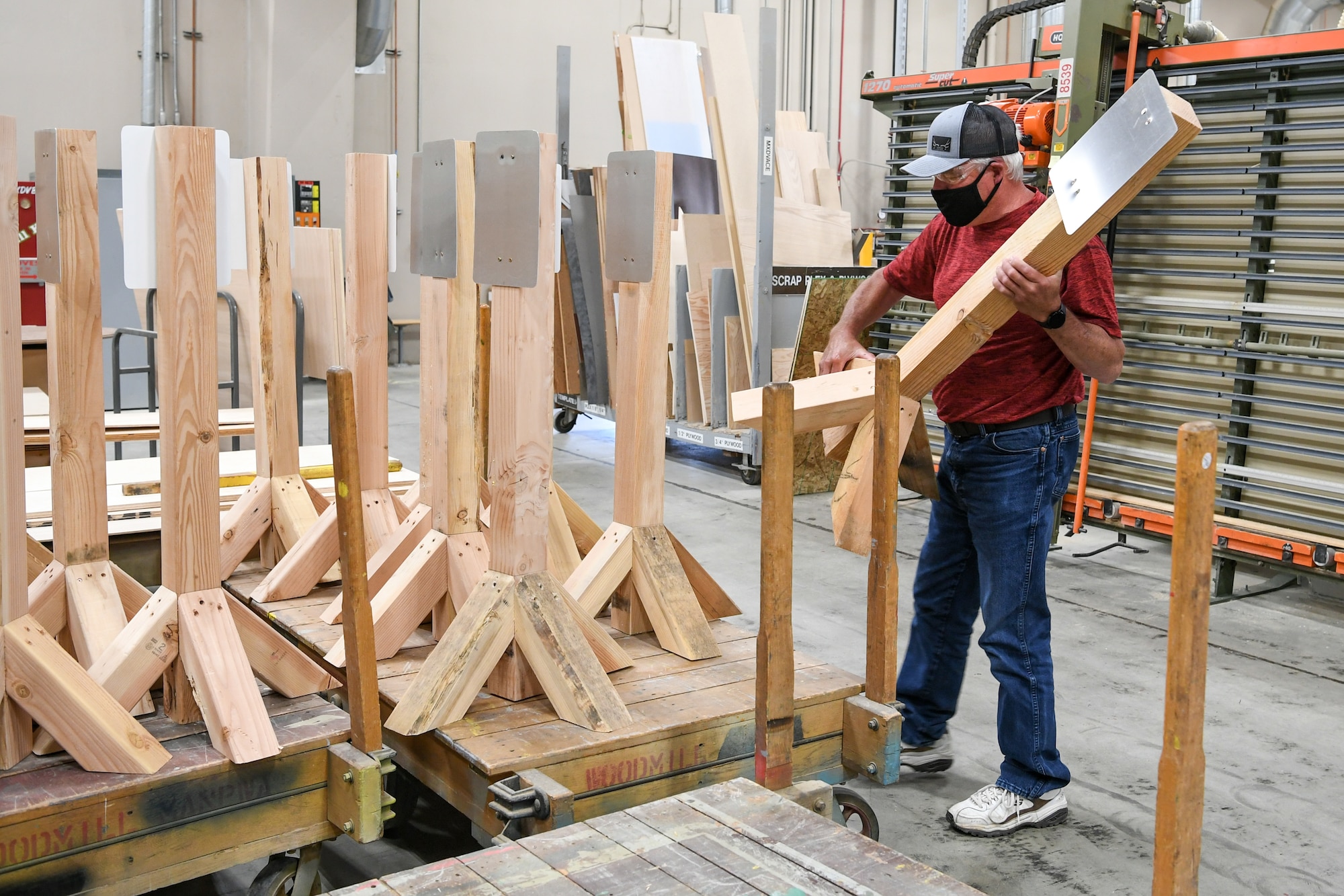 Barry Chase, 309th Maintenance Support Group's wood shop supervisor, loads a stanchion the shop built to hold hand sanitizer dispensers.