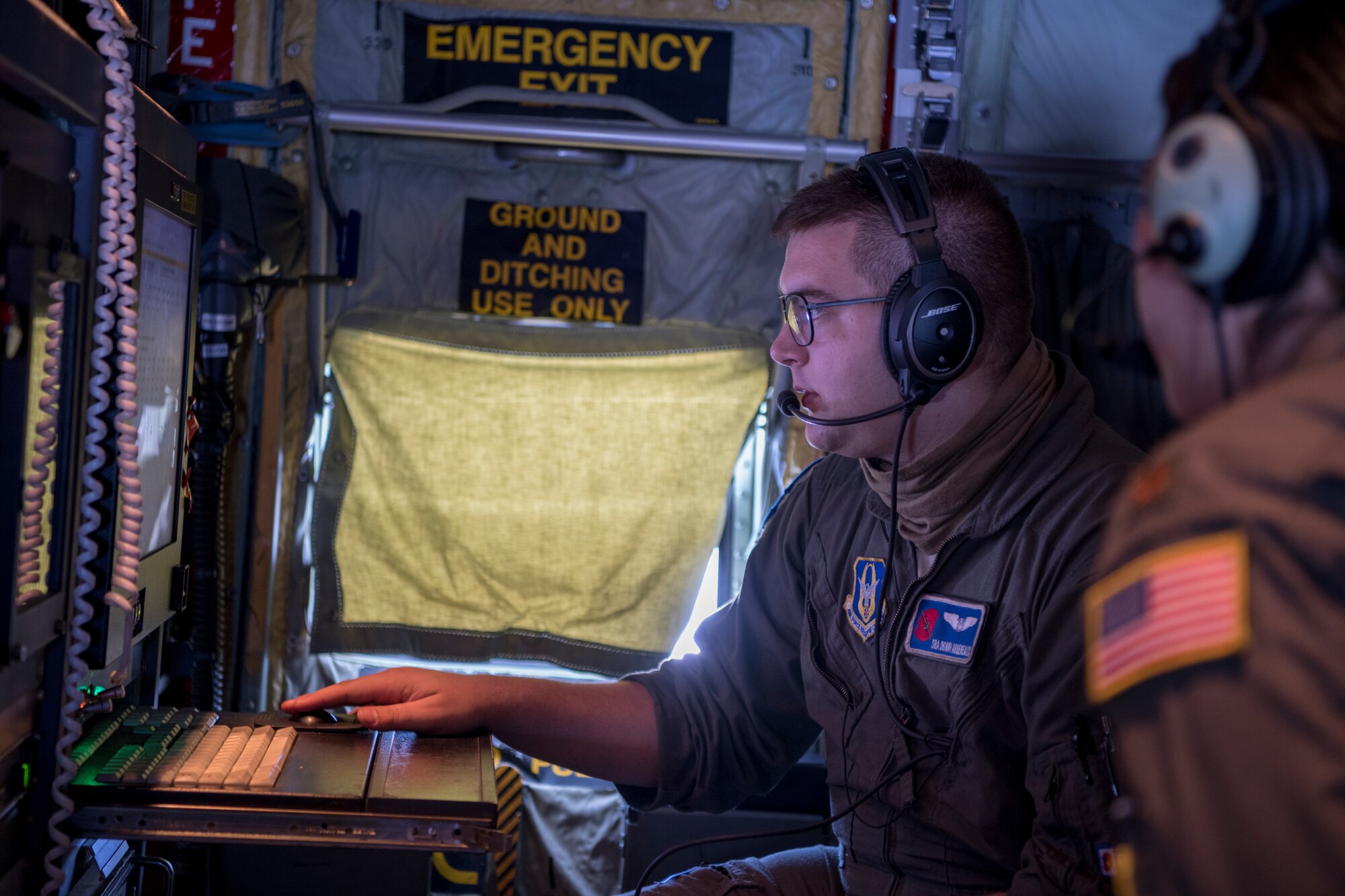 Senior Airman Donny Arseneaux, 53rd Weather Reconnaissance Squadron loadmaster, explains the data on his station to Maj. Joyce Hirai, 53rd WRS aerial reconnaissance weather officer, June 17 over St. Croix, U.S. Virgin Islands. The Hurricane Hunters deployed to St. Croix to fly training missions over the Caribbean in preparation for the 2020 hurricane season. (U.S. Air Force photo by Tech. Sgt. Christopher Carranza)