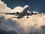 Airplane in air on blue sky and cloud background