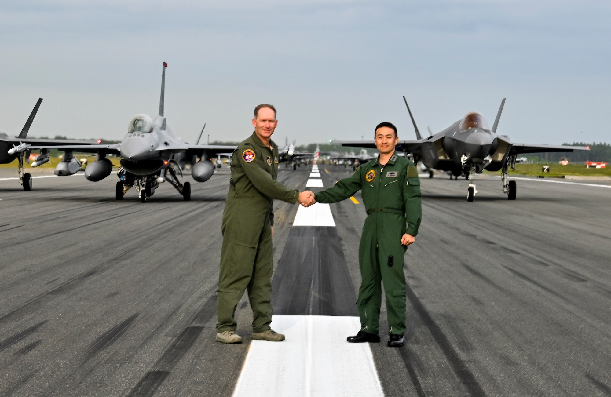 U.S. Air Force Col Kristopher Struve, left, 35th Fighter Wing commander, and Japan Air Self-Defense Force Maj. Gen. Takahiro Kubota, 3rd Air Wing and JASDF Misawa Air Base commander, shake hands in front of aircraft participating in an "Elephant Walk" at Misawa Air Base, June 22, 2020. Twelve U.S. Air Force F-16CM Fighting Falcons, 12 Koku-Jieitai F-35A Lightning II Joint Strike Fighters, two U.S. Navy EA-18G Growlers, a USN C-12 Huron, two USAF MC-130J Commando II aircraft, and a USN P-8 Poseidon participated in the Elephant Walk, which showcased Misawa Air Base’s collective readiness and ability to generate combat airpower at a moment's notice to ensure regional stability throughout the Indo-Pacific. This is Misawa Air Base’s first time hosting a bilateral and joint Elephant Walk. (U.S. Air Force photo by Tech. Sgt. Timothy Moore)