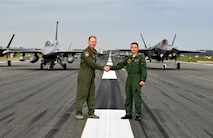 U.S. Air Force Col Kristopher Struve, left, 35th Fighter Wing commander, and Japan Air Self-Defense Force Maj. Gen. Takahiro Kubota, 3rd Air Wing and JASDF Misawa Air Base commander, shake hands in front of aircraft participating in an "Elephant Walk" at Misawa Air Base, June 22, 2020. Twelve U.S. Air Force F-16CM Fighting Falcons, 12 Koku-Jieitai F-35A Lightning II Joint Strike Fighters, two U.S. Navy EA-18G Growlers, a USN C-12 Huron, two USAF MC-130J Commando II aircraft, and a USN P-8 Poseidon participated in the Elephant Walk, which showcased Misawa Air Base’s collective readiness and ability to generate combat airpower at a moment's notice to ensure regional stability throughout the Indo-Pacific. This is Misawa Air Base’s first time hosting a bilateral and joint Elephant Walk. (U.S. Air Force photo by Tech. Sgt. Timothy Moore)