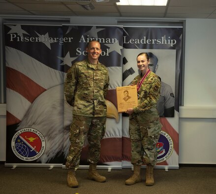 U.S. Air Force Chief Master Sgt. William Cates, 726th Air Mobility Squadron superintendent, left, presents the John L. Levitow award to Staff Sgt. Rachel Brown, 52nd Security Forces Squadron member, during the Pitsenbarger Airman Leadership School class 20-E graduation at Spangdahlem Air Base, Germany, June 19, 2020. The award is given to the ALS graduate who demonstrates the most outstanding professional leadership and academic performance. (U.S. Air Force photo by Senior Airman Melody W. Howley)