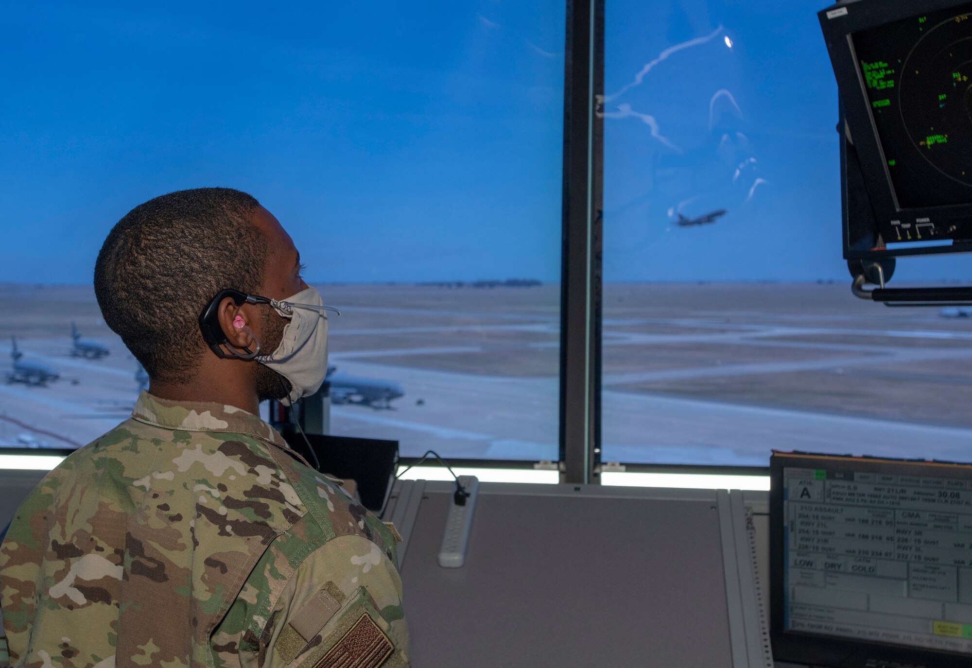 U.S. Air Force Staff Sgt. Robinson Sanon, 821st Contingency Response Squadron air traffic control journeyman, watches a KC-10 Extender depart May 5, 2020, in the control tower, at Travis Air Force Base, California. The coronavirus pandemic has had a minimal impact on the Travis Control Tower team’s 24/7mission. Air traffic controllers promote the orderly, safe and expeditious flow of air traffic under both visual and instrument controls by issuing advisories, instructions and clearances. (U.S. Air Force photo by Heide Couch)