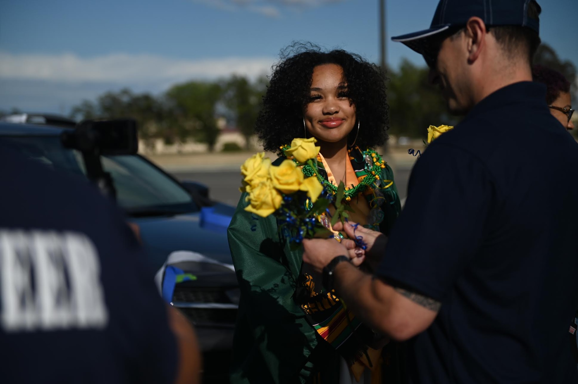 U.S Air Force Senior Master Sgt. Rey Rios, Air Force Sergeants Association Chapter 1320 senior advisor, gives a rose to Cheyenne Robinson, a Vanden High School graduate, June 12, 2020, at Travis Air Force Base, California. The base’s local AFSA Chapter 1320, Airman and Family Readiness Center, and chaplain corps collaborated for the “honk at a grad” parade to celebrate high school graduates unable to experience a graduation ceremony during the COVID-19 pandemic. (U.S. Air Force photo by Airman 1st Class Karla Parra)