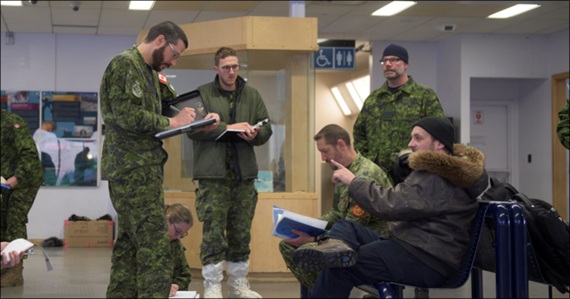 Reconnaissance team members from 2 Air Expeditionary Wing interview the Rankin Inlet Airport manager during their survey visit to Rankin Inlet, Nunavut, Jan. 28, 2020.