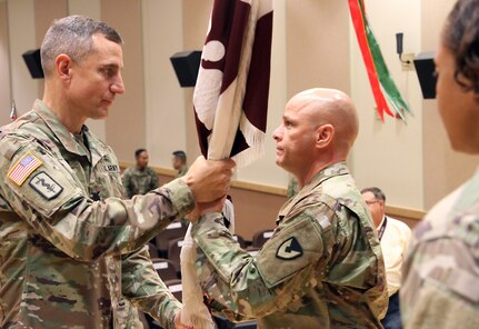 Col. Derek C. Cooper, left, passes the colors to Lt. Col. Marcus D. Perkins, signifying his assumption of command of the U.S. Army Medical Materiel Center-Korea, a direct reporting unit of Army Medical Logistics Command. Cooper, commander of the 65th Medical Brigade, served as the stand in for AMLC Commander Col. Michael Lalor, who presided over the June 18 ceremony remotely.