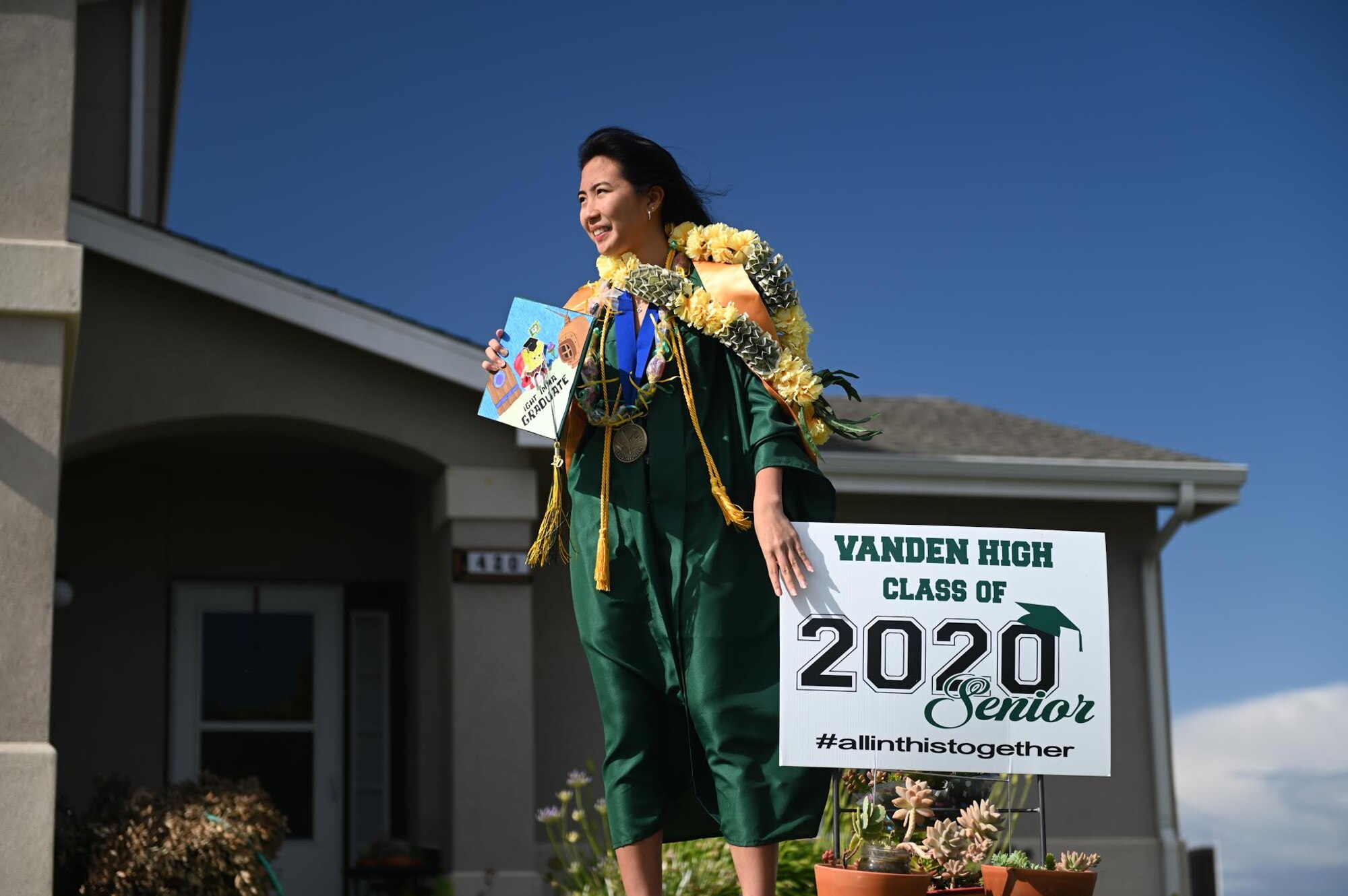 Vanden High School Salutatorian, Justine M. Legaspi, waits for the “honk at a grad” parade to pass her house at Travis Air Force Base, California, June 12, 2020. The parade celebrated high school seniors unable to experience a graduation ceremony due to the COVID-19 pandemic. The event was a collaboration between the base’s local Air Force Sergeants Association Chapter 1320, Airman and Family Readiness Center, and the Chaplain Corps. (U.S. Air Force photo by Airman 1st Class Karla Parra)