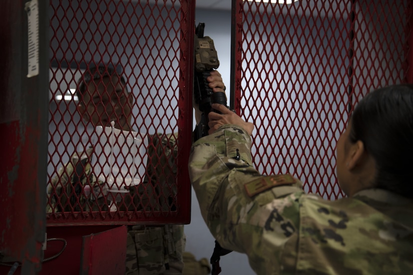 Senior Airman Cindy Argueta, 316th Security Support Squadron armorer, hands off an M4 carbine to Airman 1st Class Julian Almazan, 316th Security Forces Squadron defender, before his shift on Joint Base Andrews, Md., June 17, 2020. Defenders are issued a minimum of one lethal force weapon, one less than lethal force weapon, and a radio before each shift.