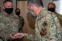 Air Force Chief of Staff Gen. David L. Goldfein coins Tech Sgt. Eric, 30th Reconnaissance Squadron flight chief, in front of his peers at Creech Air Force Base, Nevada.