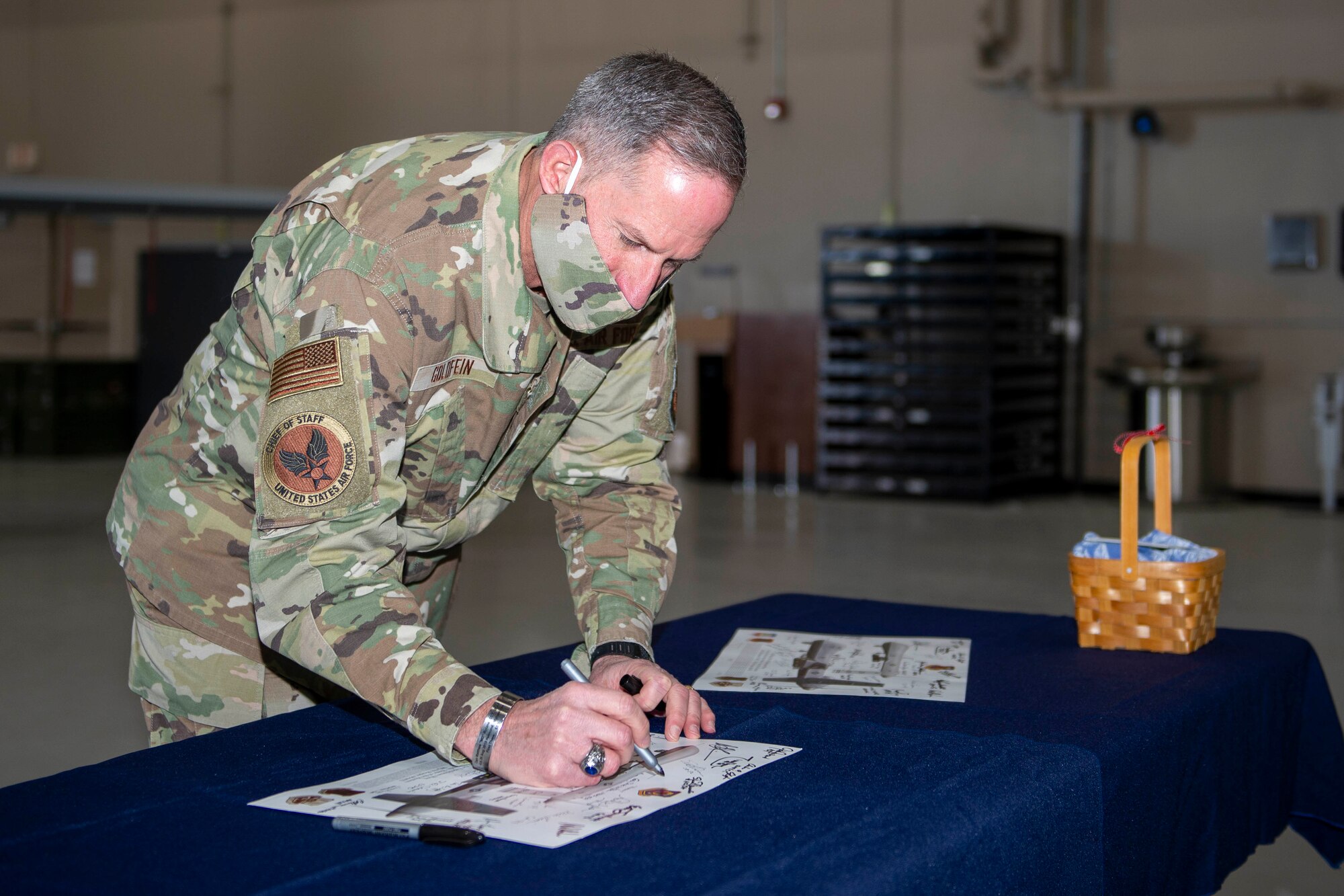 Air Force Chief of Staff Gen. David L. Goldfein signs a lithograph after visiting Creech Air Force Base, Nevada.