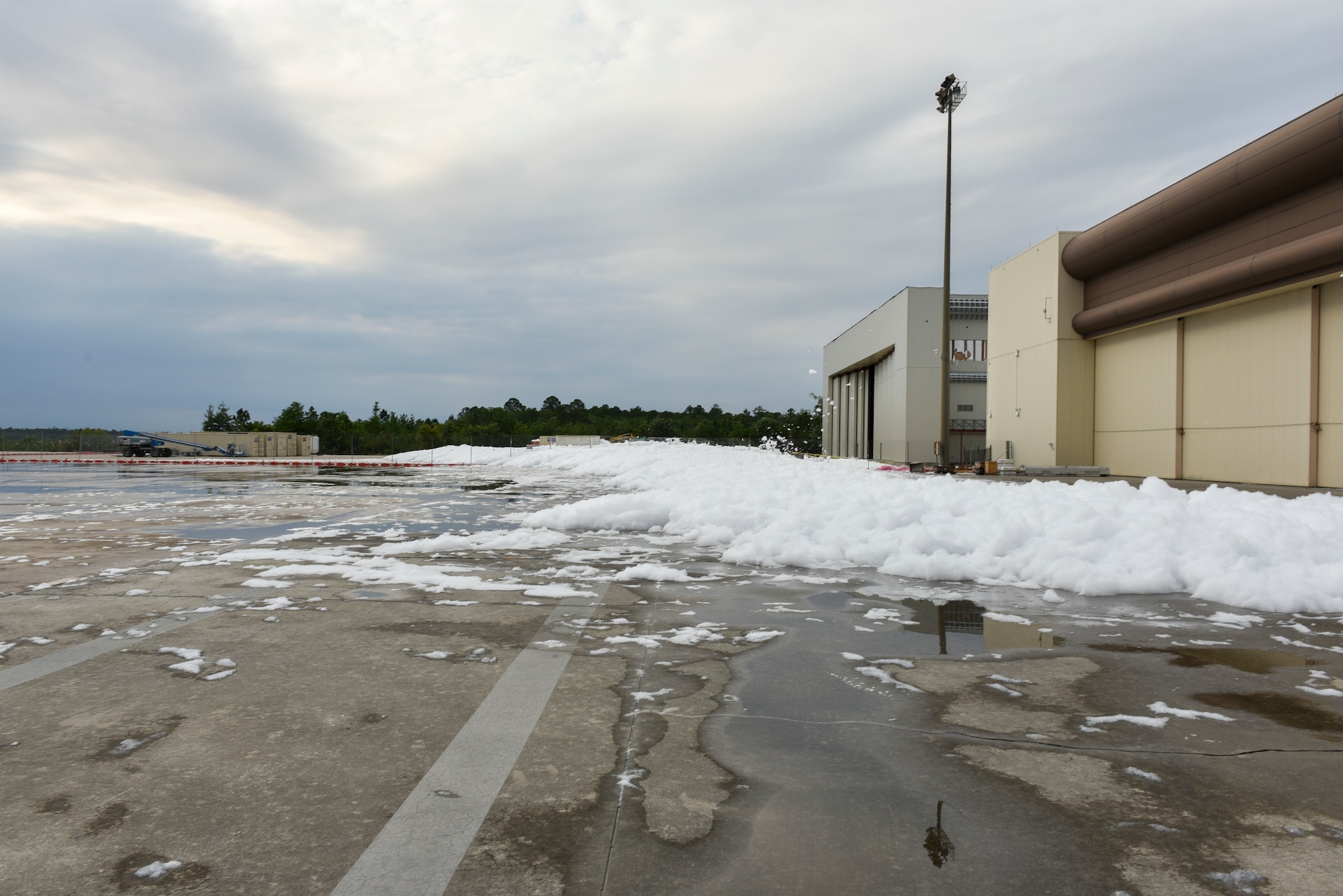 white foam coming out of an aircraft hangar onto a flight line