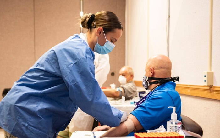 Lab Tech wraps a bandage on patient.