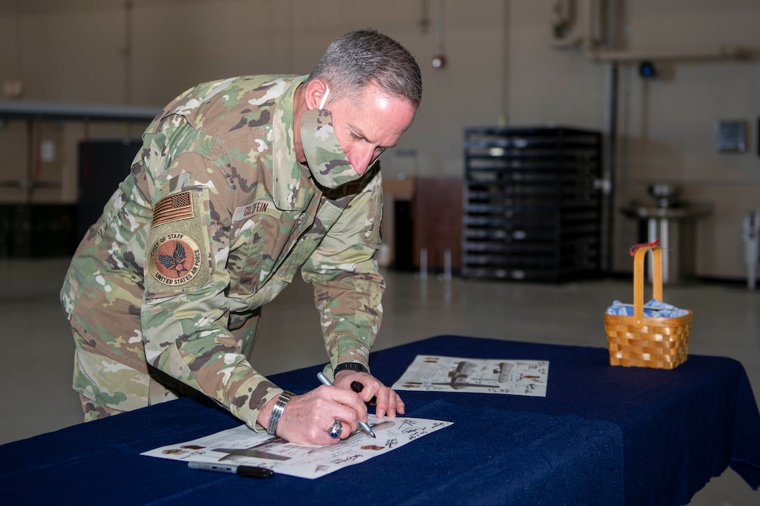 Air Force Chief of Staff Gen. David L. Goldfein signs a lithograph after visiting Creech Air Force Base, Nevada.