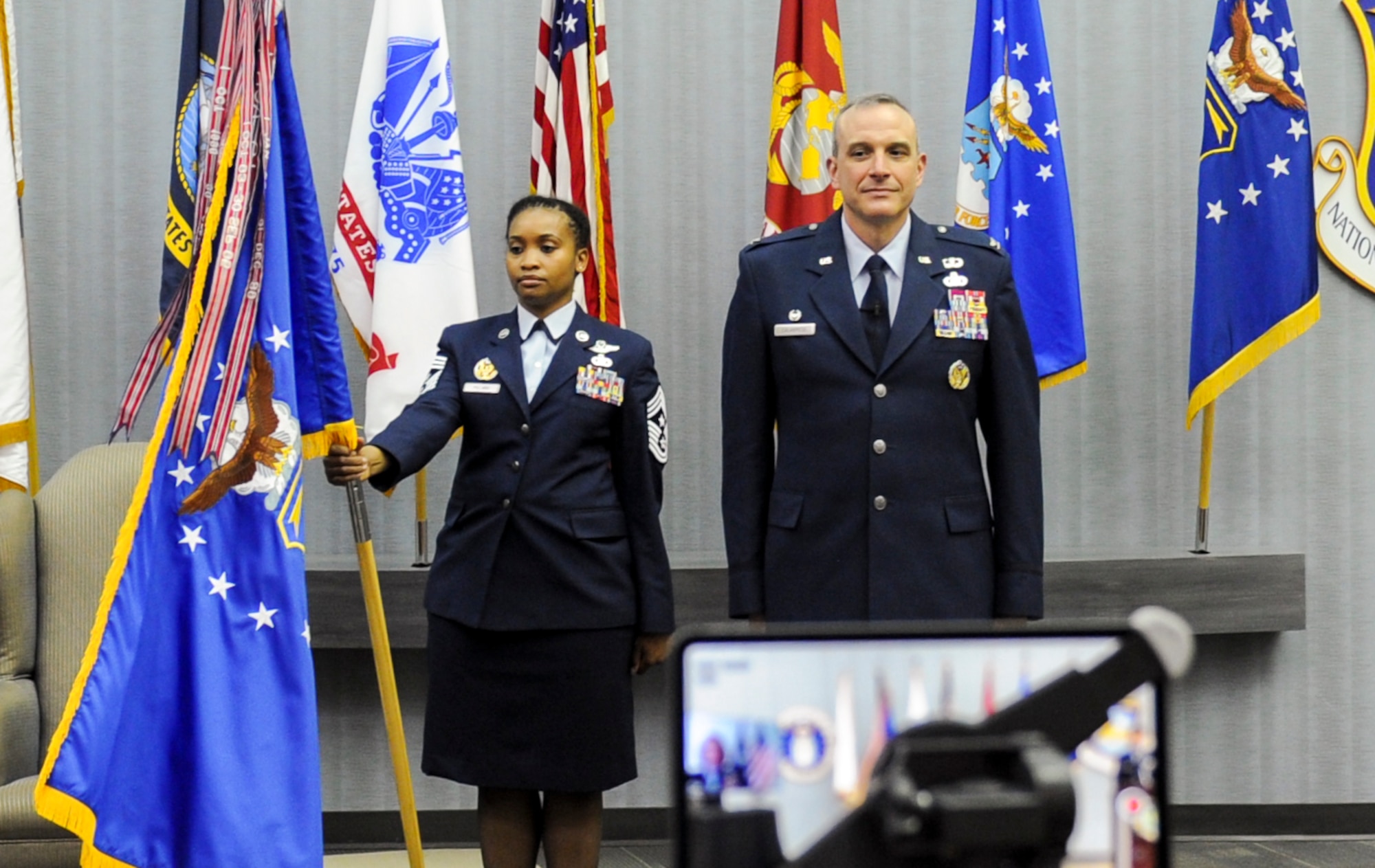 Chief Master Sgt. Kimberly Pollard, National Air and Space Intelligence Center Command Chief, stands with the NASIC flag during a ceremony honoring Col. Maurizio Calabrese as he assumed command of the Center June 9, 2020.