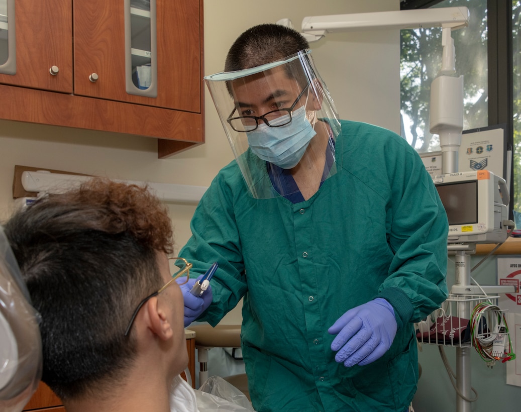 U.S. Air Force Airman 1st Class Francis Raymundo, 60th Dental Squadron dental technician, wears a reusable face shield while conducting an examination at Travis Air Force Base, California, June 5, 2020. The 60th Aerospace Medicine Squadron Bioenvironmental Engineering Flight, 60th Air Mobility Wing Phoenix Spark innovation cell, and 60th Maintenance Squadron collaborated to design and manufacture personal protective equipment for David Grant USAF Medical Center. As of June 1, DGMC had received 153 face shields in response to the COVID-19 pandemic. (U.S. Air Force photo by Heide Couch)