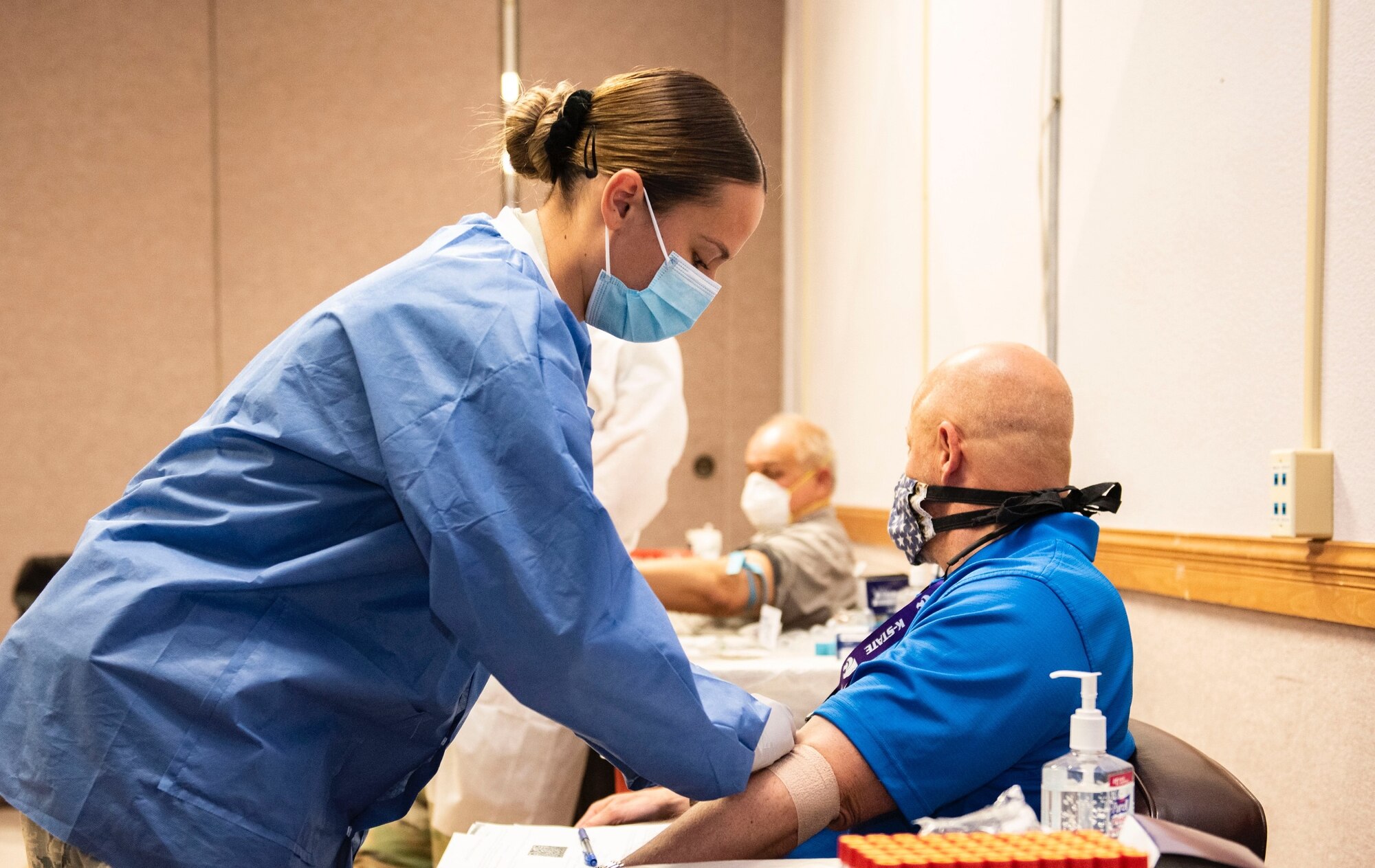 Lab Tech wraps a bandage on patient.