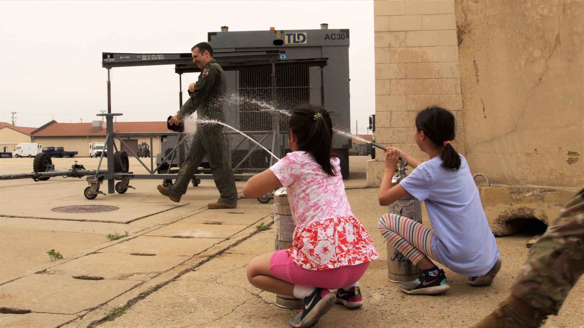 Lt. Col. Georgescu is sprayed with water by his two youngest daughters.