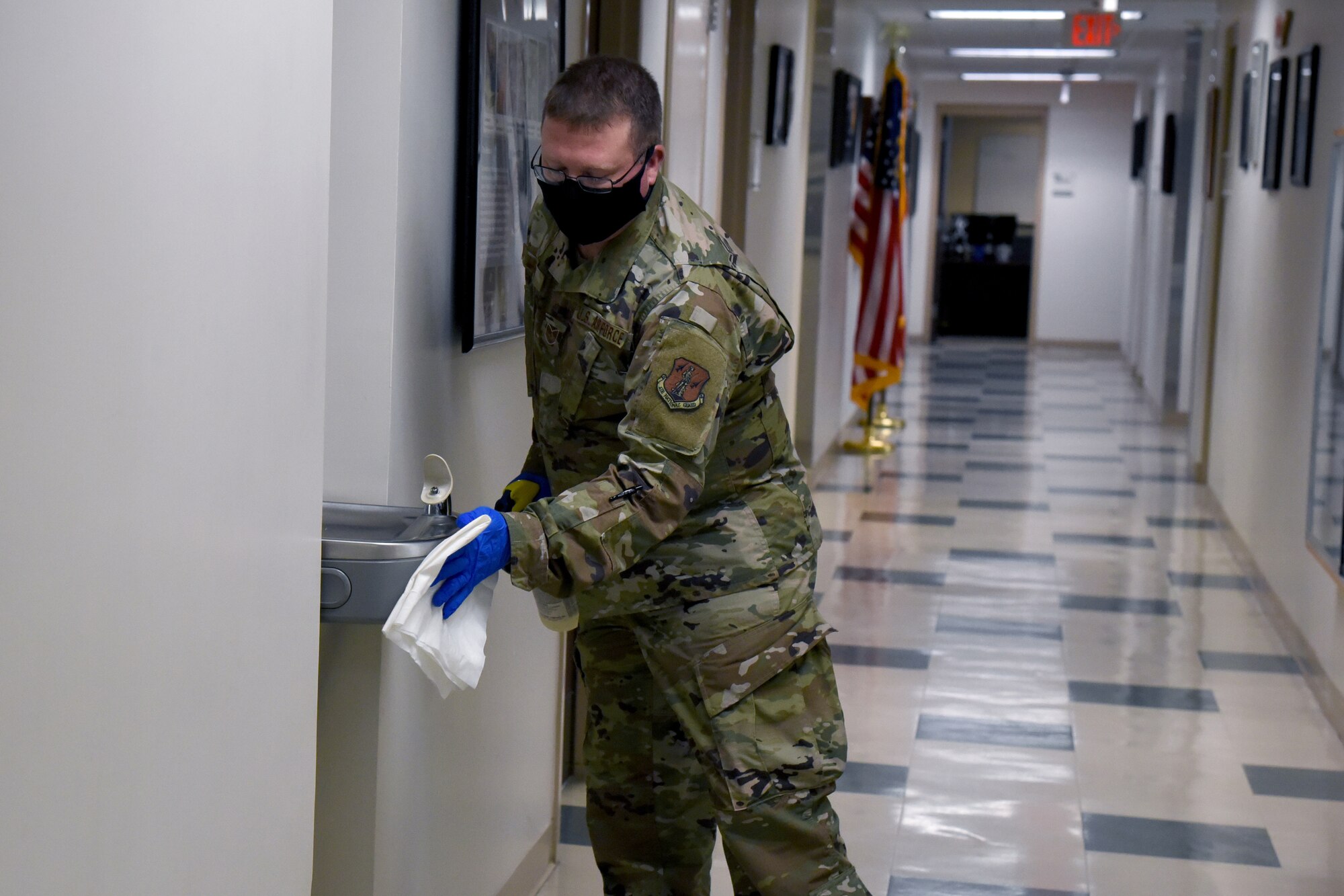 U.S. Air Force Tech. Sgt. Kelvin Lanier a COVID-19 infection control team volunteer disinfects frequently used areas on the installation at the 117th Air Control Squadron at Hunter Army Airfield June 16, 2020.  The base infection control teams minimize the potential spread of COVID-19 for unit members by disinfecting common areas and workplaces as a precautionary measure. (U.S. Air National Guard photo by Staff Sgt. Jamila Haven)