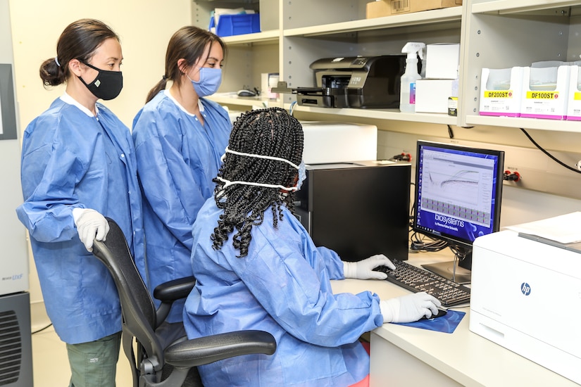 BAMC’s molecular team members load COVID-19 patient samples into an analyzer.