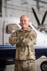 Airman stands in front of aircraft