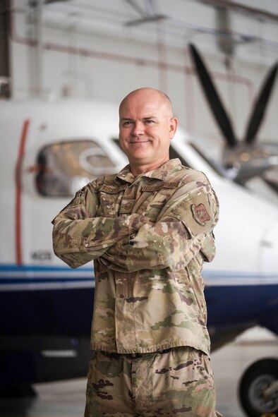 Airman stands in front of aircraft