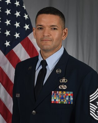 shoulder length photo 89th Airlift Wing commander with US flag in background