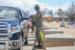 Senior Airman Elijah Thompkins, 75th Medical Group, hands a prescription over to a beneficiary March 23, 2020, at Hill Air Force Base, Utah. The 75th Medical Group Satellite Pharmacy is providing curbside service until further notice in front of the Base Exchange shopping center in support of social distancing recommendations and to increase efforts to mitigate further spread of the novel coronavirus.(U.S. Air Force photo by Cynthia Griggs)