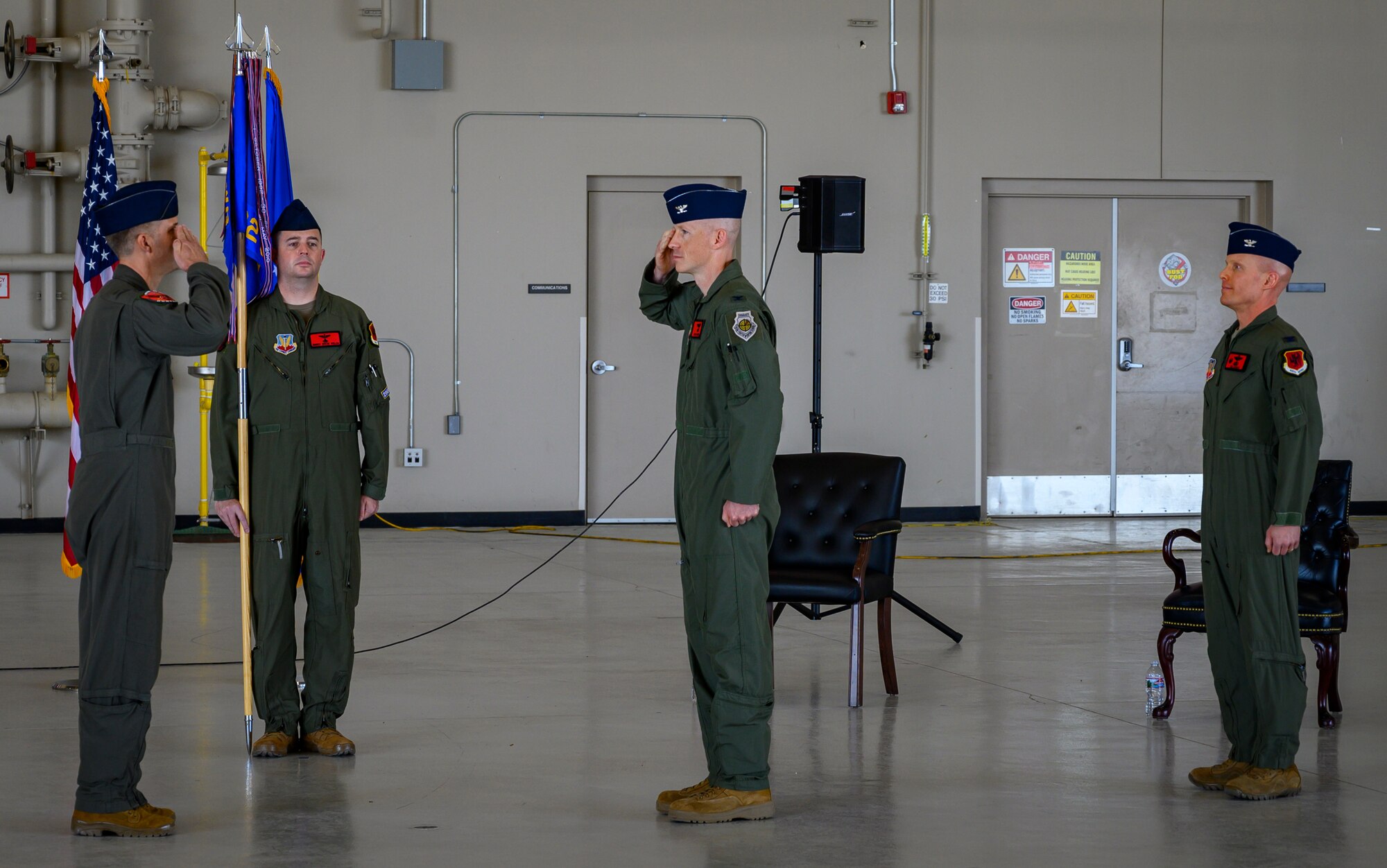 U.S. Air Force Col. John Powers, center, 432nd Operations Group commander, assumes command from presiding official Col. Stephen Jones, left, 432nd Wing/432nd Air Expeditionary Wing commander, during the 432nd OG change of command ceremony at Creech Air Force Base.