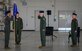 U.S. Air Force Col. John Powers, center, 432nd Operations Group commander, assumes command from presiding official Col. Stephen Jones, left, 432nd Wing/432nd Air Expeditionary Wing commander, during the 432nd OG change of command ceremony at Creech Air Force Base.