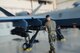 Airmen wearing facemasks compete to arm an MQ-9 Reaper during a quarterly load crew competition.