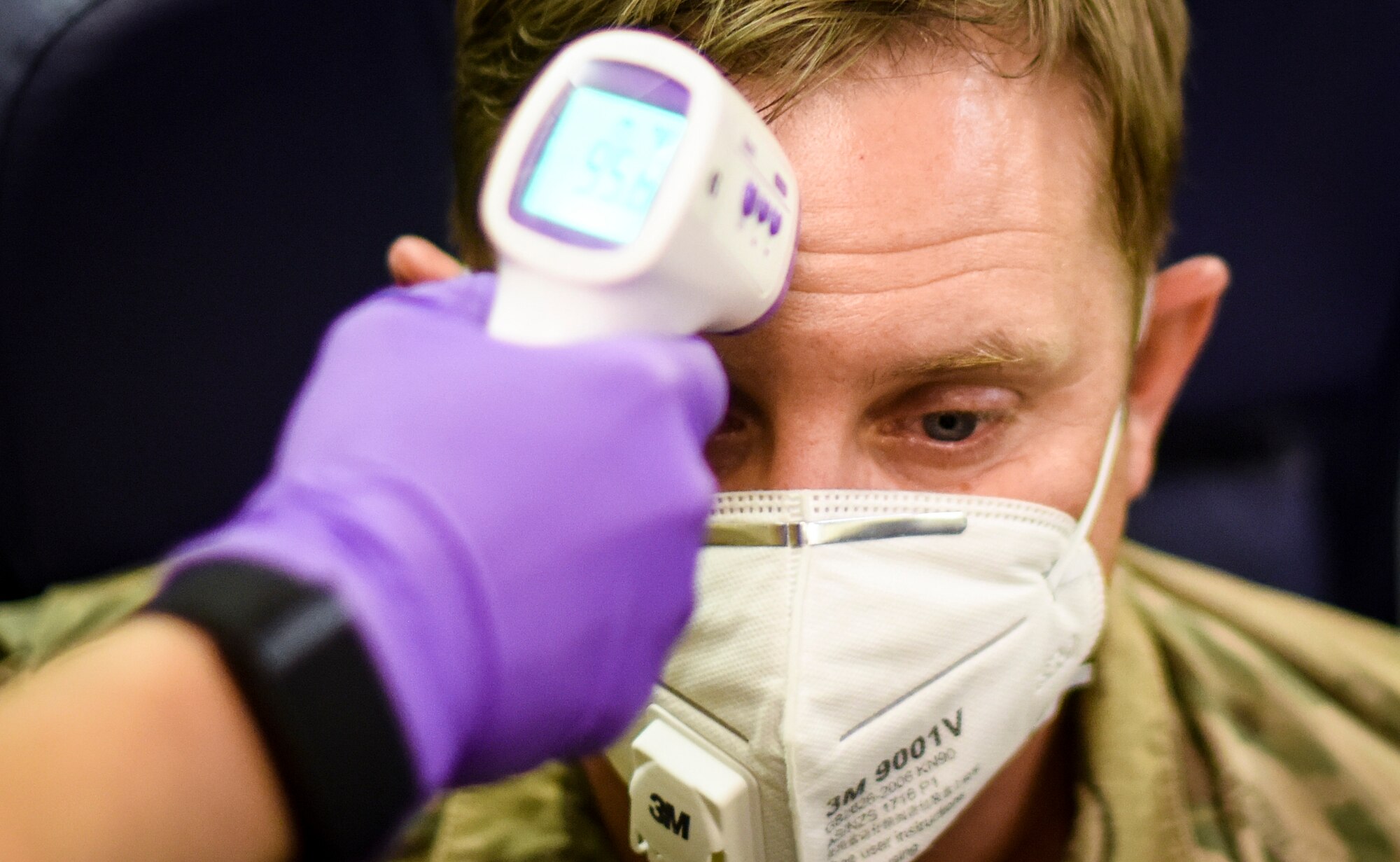 U.S. Air Force Senior Airman Lauren Frensley, 386th Expeditionary Medical Group flight medical technician performs COVID-19 screenings on an inbound jet transporting service members at Cargo City, Kuwait, June 16, 2020. The 386th EMDG screens personnel from multiple branches that process through Cargo City, including the U.S. Air Force, U.S. Army, and Marine Corps. (U.S. Air Force photo by Senior Airman Kevin Tanenbaum)