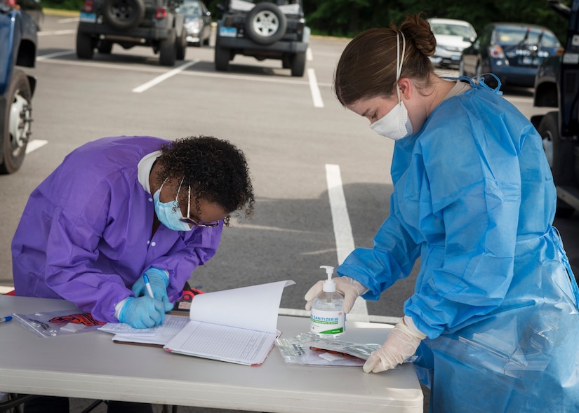 U.S. Air Force Staff Sgt. Carley Dolan (right), 103rd Medical Group aerospace medical technician, delivers a COVID-19 testing swab for analysis by civil support team personnel at Bradley Air National Guard Base, East Granby, Connecticut, June 19, 2020. The 103rd Medical Group worked in partnership with the Connecticut National Guard 14th Civil Support Team, New York National Guard 24th Civil Support Team, and Connecticut Department of Public Health to provide COVID-19 testing to Connecticut Air National Guard personnel. (U.S. Air National Guard photo by Staff Sgt. Steven Tucker)