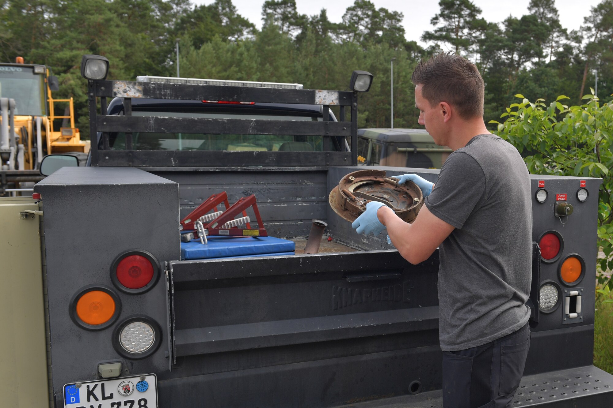 A man placing a brake assembly in a truck bed.