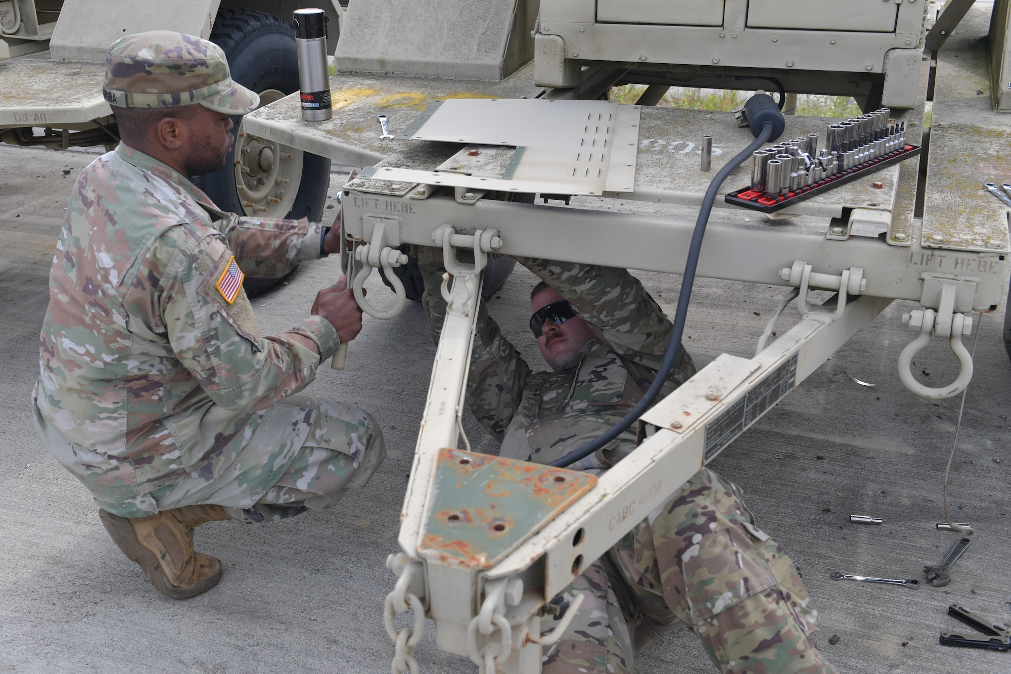 Two men working on a trailer.