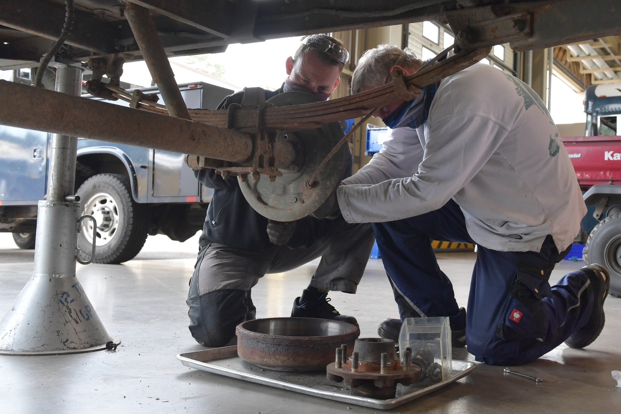 Two mechanics working on a brake assembly.