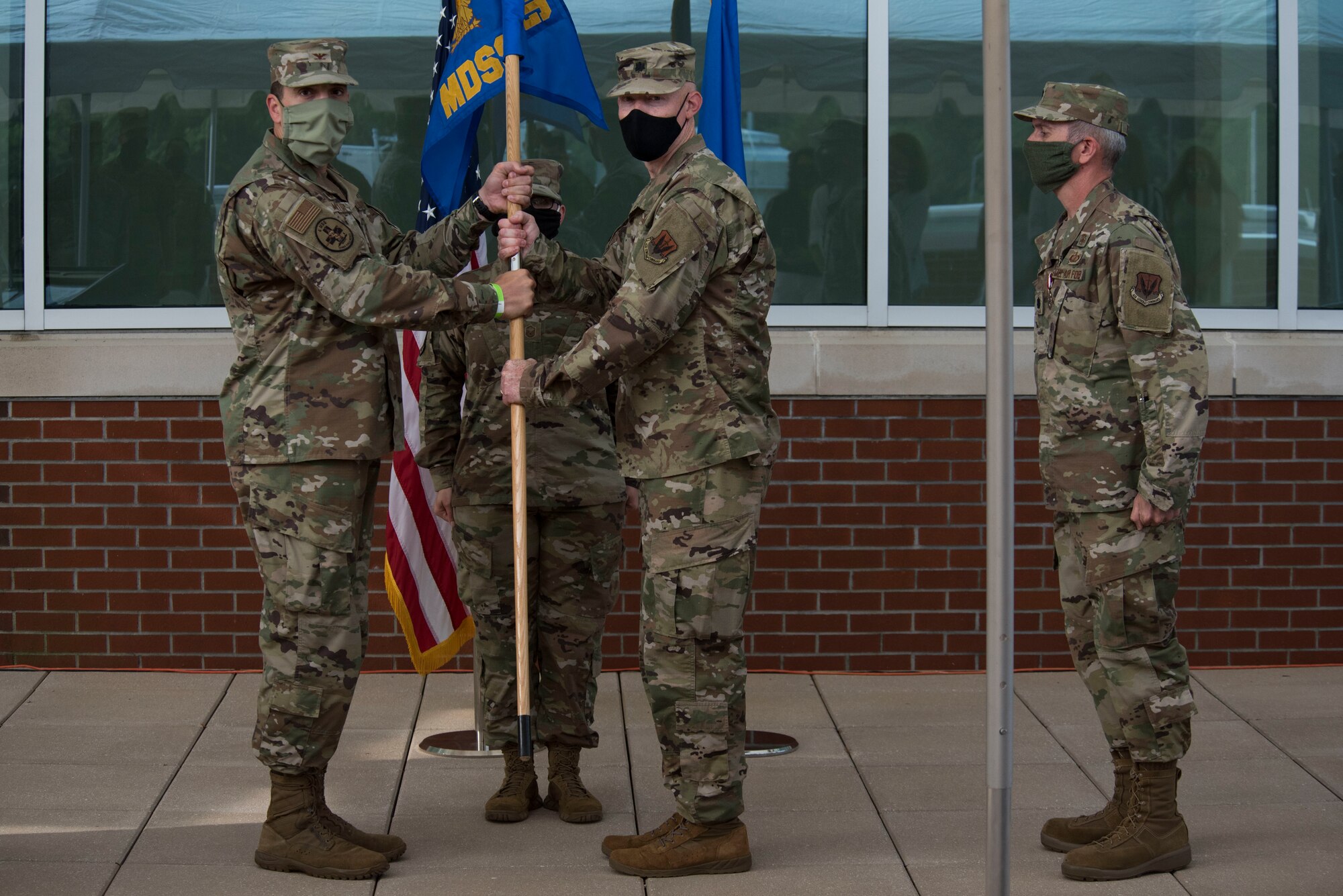 Col. William Malloy, 4th Medical Group commander, passes the guideon to Lt. Col. Joseph Popham, as Popham assumes command of the 4th Medical Support Squadron during a ceremony at the Thomas Koritz Clinic, Seymour Johnson Air Force Base, North Carolina, June 23, 2020. Popham arrived from Joint Base San Antonio Lackland, Texas. (U.S. Air Force photo by Senior Airman Kenneth Boyton)