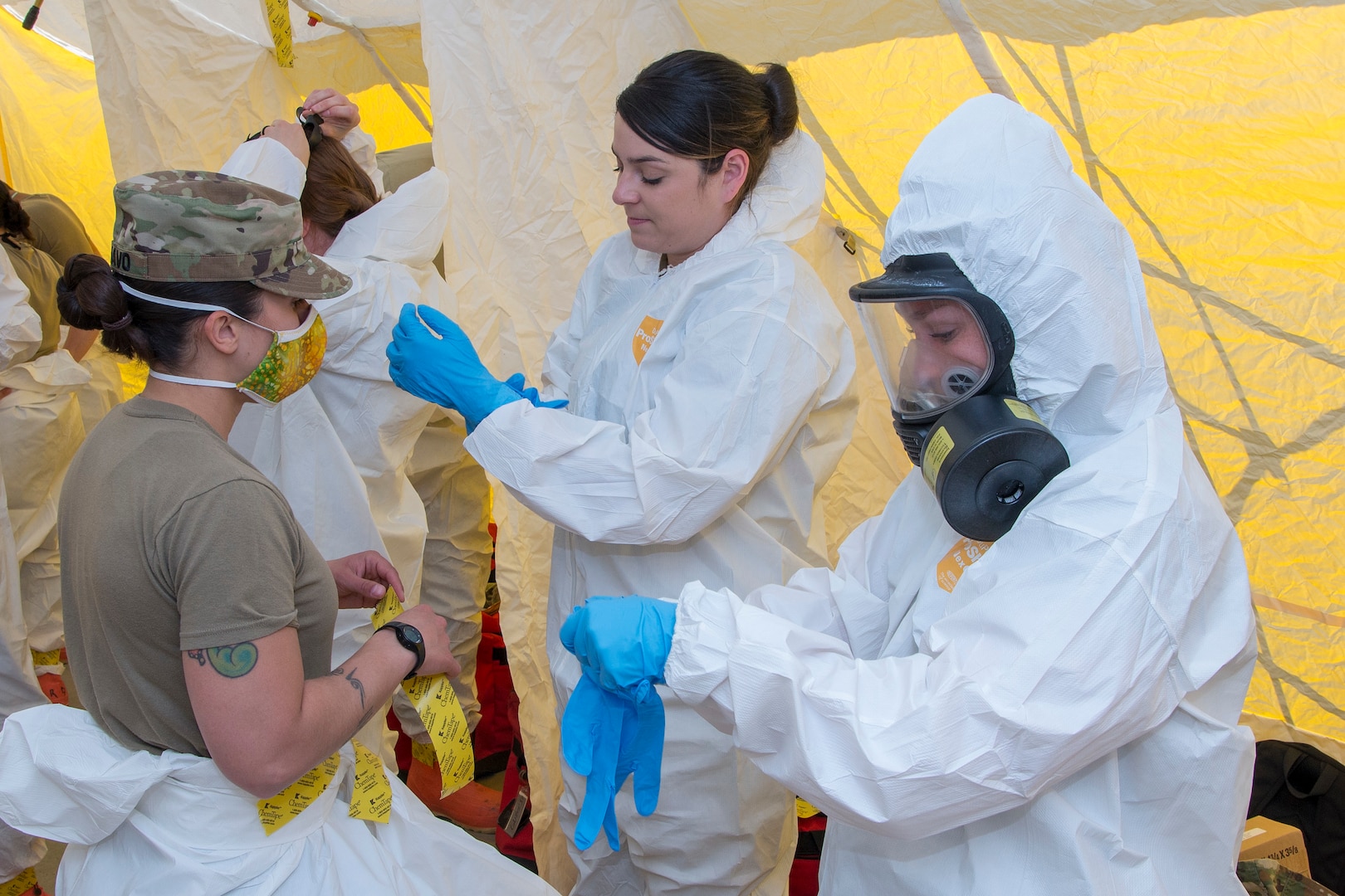 U.S. Army Sgt. Meghan Schiavo, 3650th Support Maintenance Co., Air Force Staff Sgt. Force Lavette Atkins, 140th Medical Squadron, Buckley Air Force Base, Spc. Jennifer Sweitzer, 928th Ft. Carson, don personal protective equipment at a long-term care facility in Adams County, Colo., April 21, 2020. Nearly 70 Colorado National Guard members from the Chemical, Biological, Radiological, Nuclear and high-yield (CBRNE) Enhanced Response Force Package (CERFP) tested 300 patients and staff members.