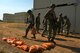 U.S. Air Force Airmen place bags of dirt on the ground to build a defensive fighting position