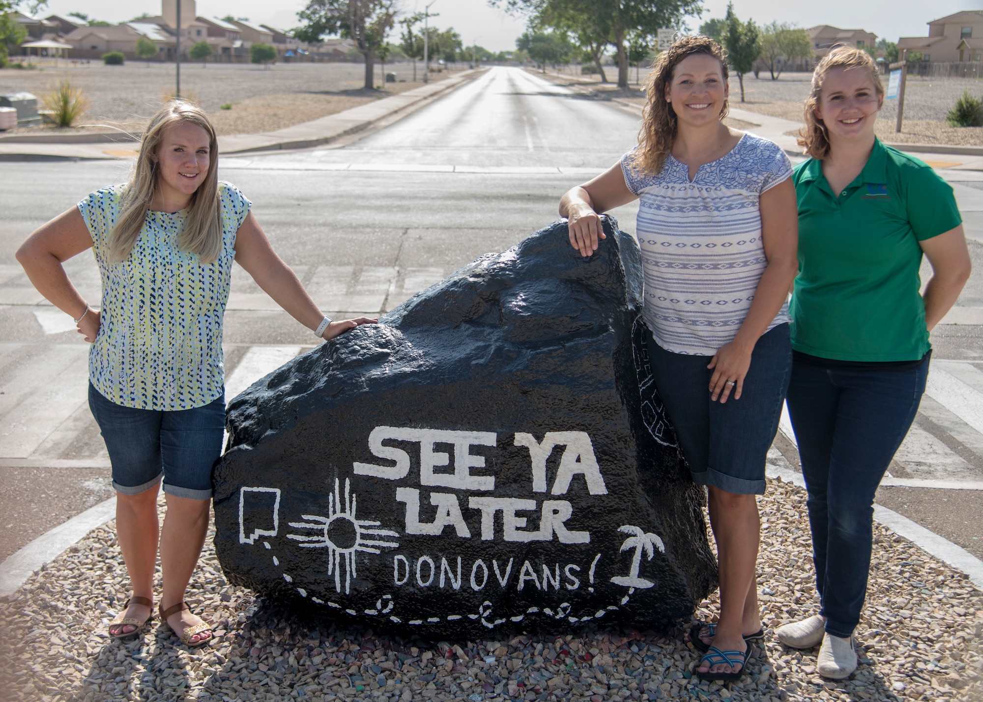 (from left to right) Jackie Ottesen, 6th Attack Squadron key spouse, Maj. Naomi Donovan, 924th Aircraft Maintenance Squadron commander and 2018 49th Mission Support Group key spouse, and Kim Furry, 49th Force Support Squadron community activity center manager, pose for a photo at the “Holloman rock,” June 23, 2020, on Holloman Air Force Base, N.M. Holloman key spouses paint this decorative rock approximately every two weeks to highlight fun events, holidays and general base awareness activities in order to promote community, cohesion and aid in putting a smile on Team Holloman members’ faces. (U.S. Air Force photo by Senior Airman Collette Brooks)