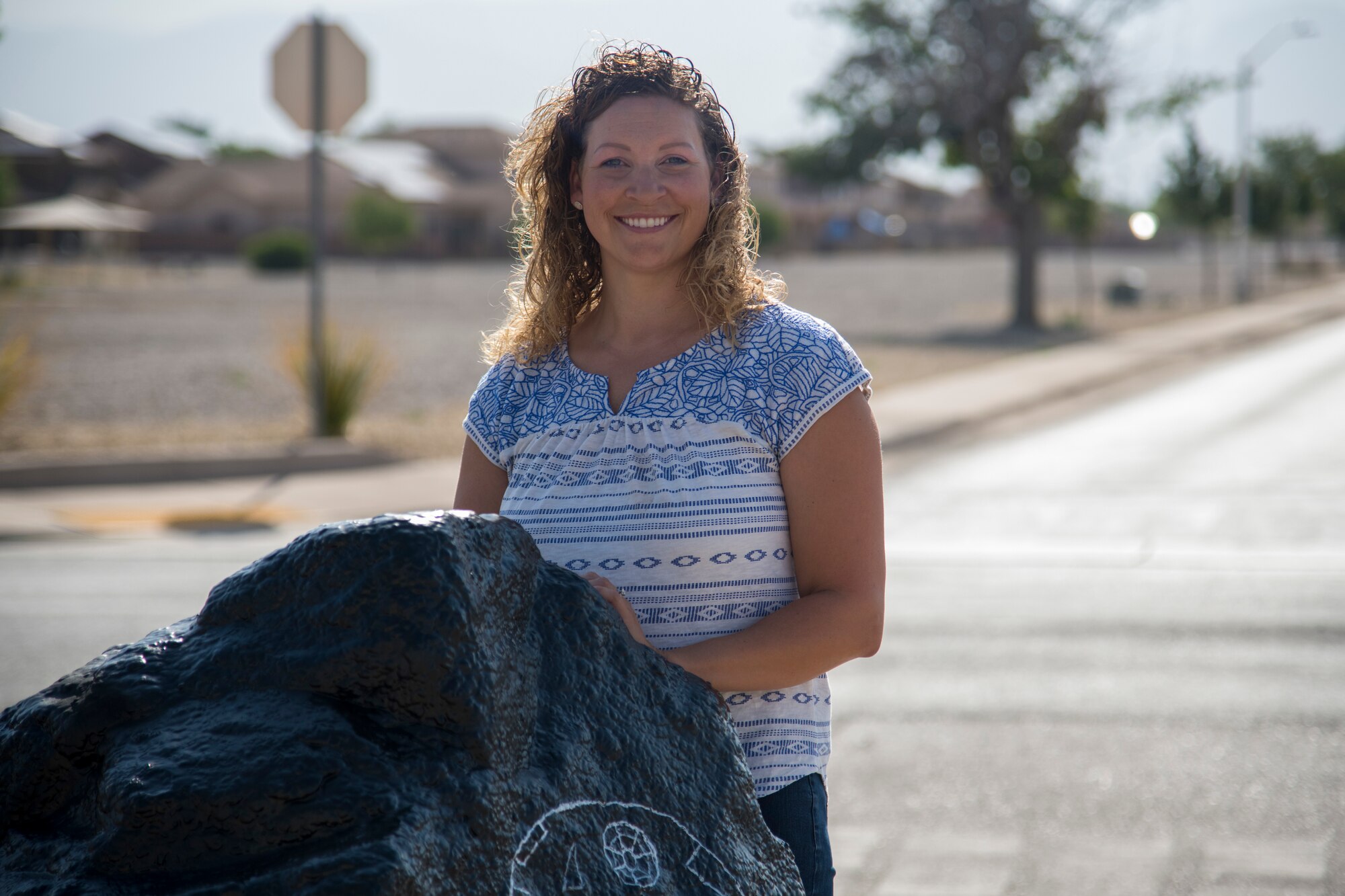 Maj. Naomi Donovan, 924th Aircraft Maintenance Squadron commander and 2018 49th Mission Support Group key spouse, poses for a photo at the “Holloman rock,” June 23, 2020, on Holloman Air Force Base, N.M. Donovan and her team use spray and acrylic paints to update the rock approximately every two weeks depending on what current events are taking place. (U.S. Air Force photo by Senior Airman Collette Brooks)