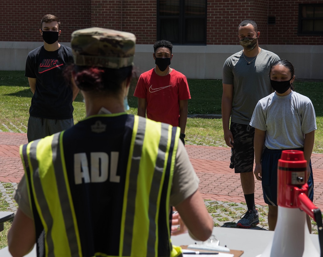 Competitors participating in the Tunnell Hall Farmer’s Walk Kettle Bell Challenge, listen to a brief before beginning the competition at Joint Base Langley-Eustis, Virginia, June 19, 2020. The timed event required competitors to carry kettlebells around each of the three floors making up Tunnell Hall before returning to the starting line. (U.S. Air Force photo by Senior Airman Marcus M. Bullock)