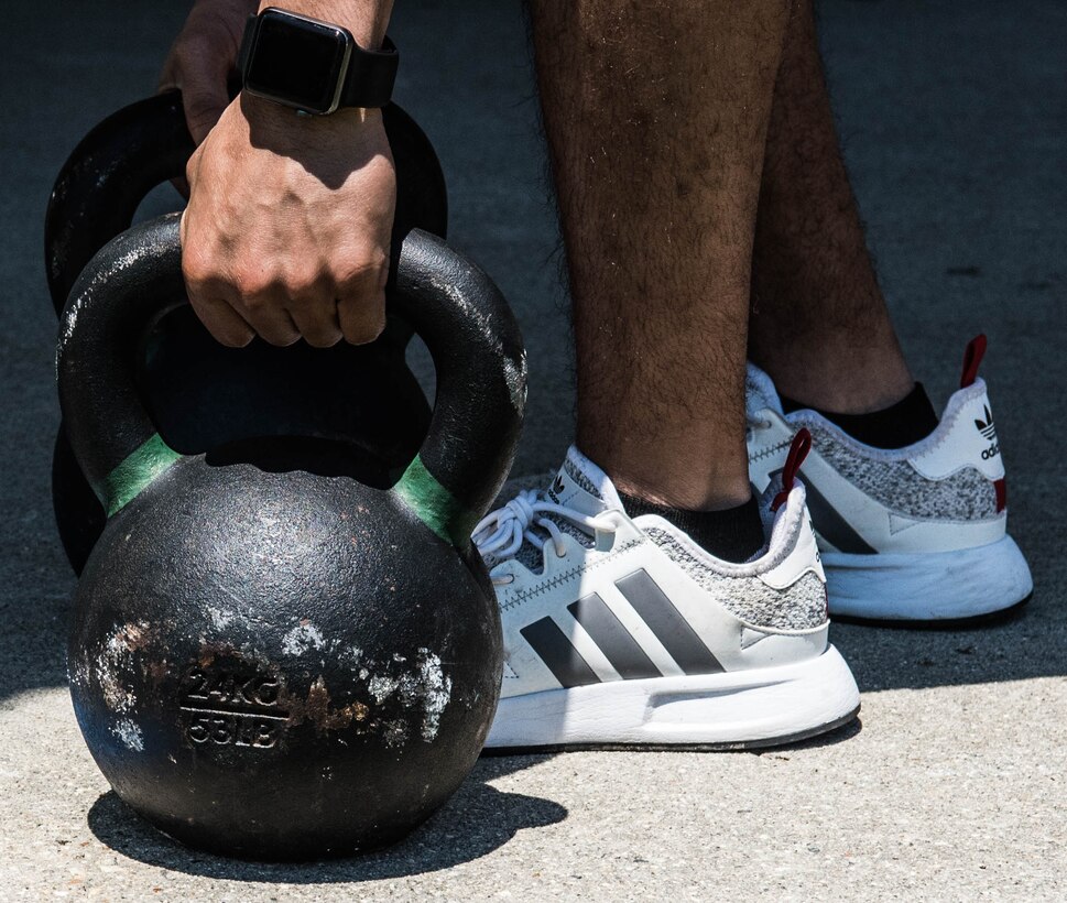 A competitor grabs the kettle bells before their turn during the Tunnell Hall Farmer’s Walk Kettle Bell Challenge at Joint Base Langley-Eustis, Virginia, June 19, 2020. The challenge helped Airmen build comradery by engaging in friendly competition while adhering to safety measures in place. (U.S. Air Force photo by Senior Airman Marcus M. Bullock)