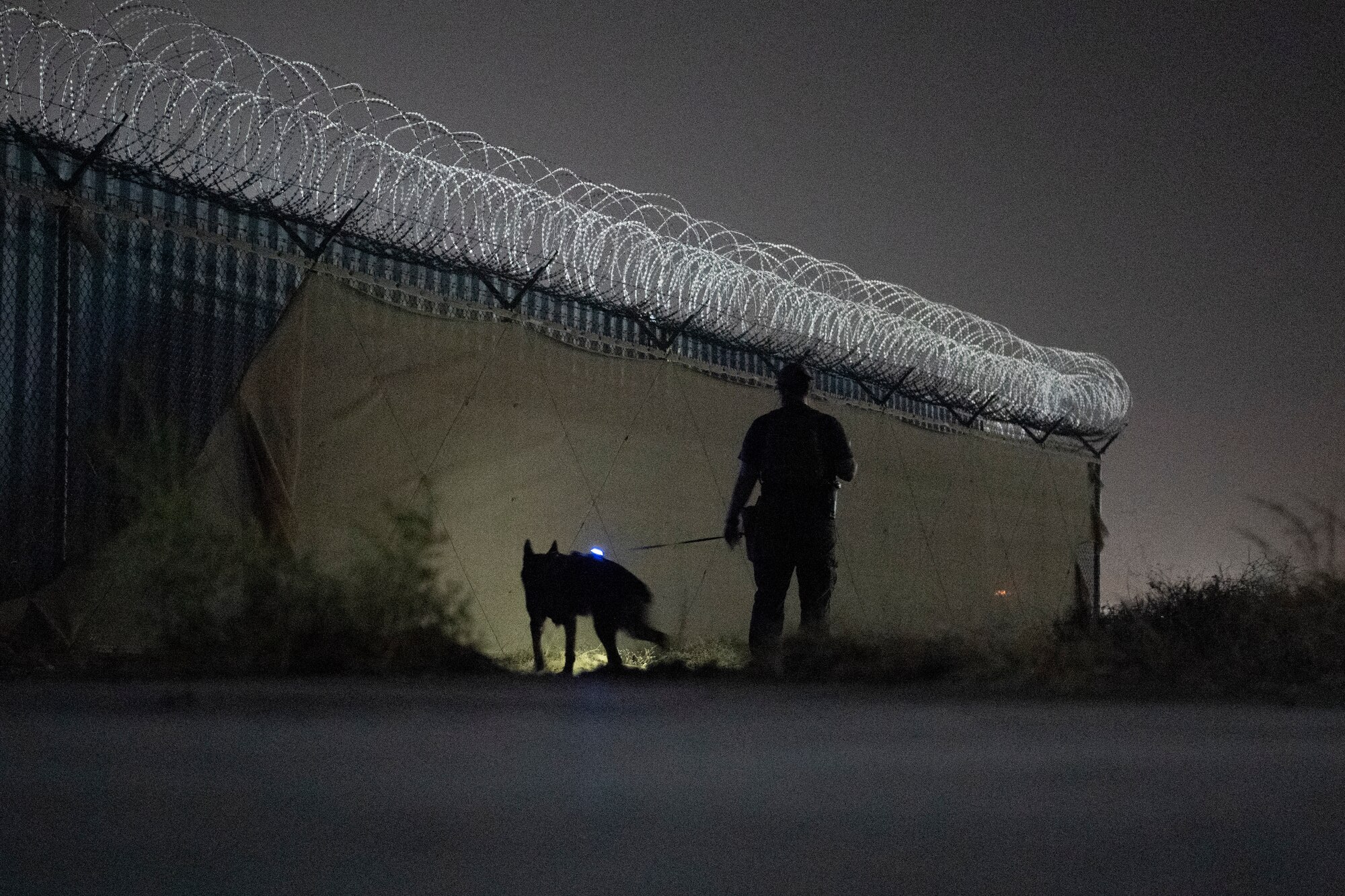 MWD handler and canine patrol perimeter fence