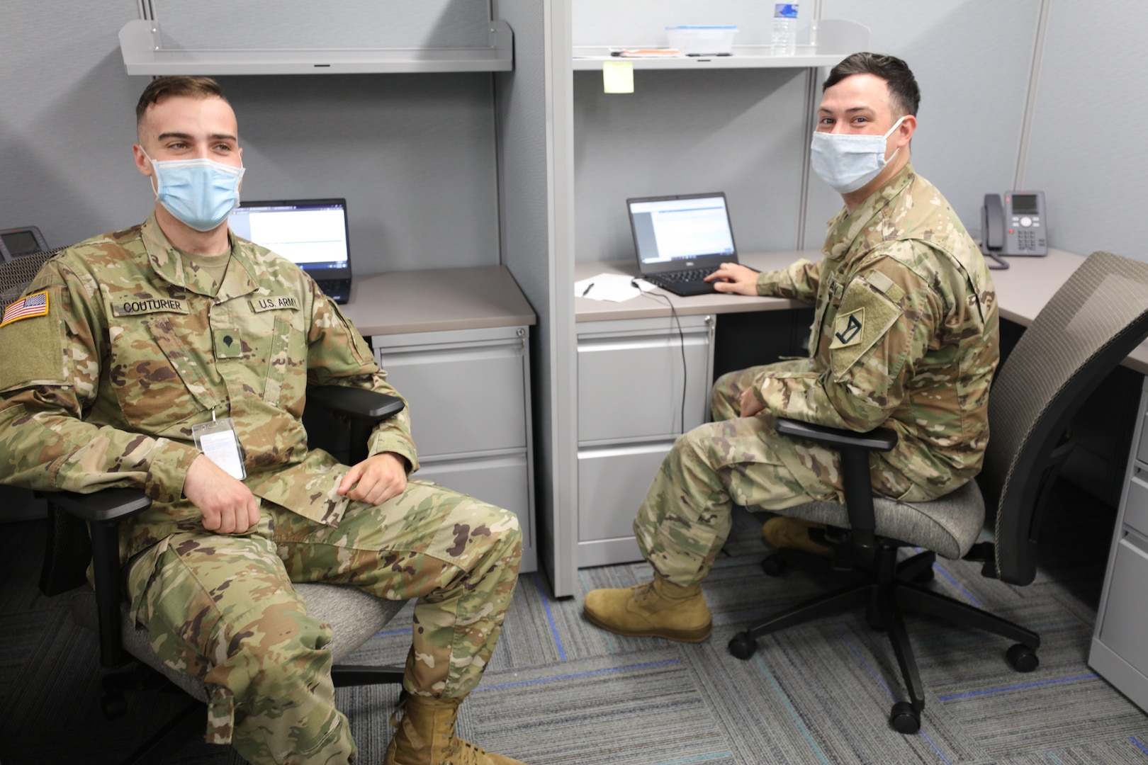 Spc. Lionel Courturier and Spc. William Casey, combat engineers with the 182nd Engineer Company (SAPPER), Massachusetts National Guard, take a quick break to brief the plans for the unit patch and T-shirt they designed while assigned to Task Force Steel Dragon June 18, 2020.  TF Steel Dragon is helping process a surge in unemployment cases submitted during the COVID-19 pandemic.