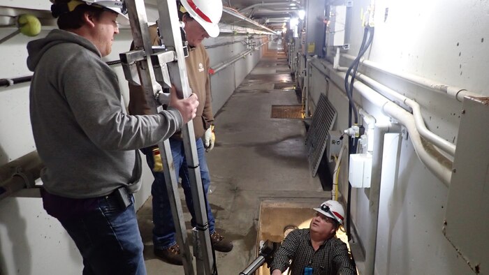 From left to right: Matthew Flanagan, Kreg Buryta and Jay Haugen testing the orifice debris plunger.